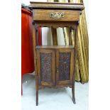 A 1920s stained oak smoker's companion with an arrangement of open shelves,