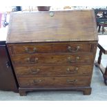 An early 19thC ebony inlaid mahogany bureau, the fall flap enclosing a fitted interior,