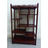 A modern exotic hardwood netsuke display stand, comprising an arrangement of staggered shelves,