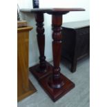 A pair of modern mahogany finished torcheres, each with a reeded column,