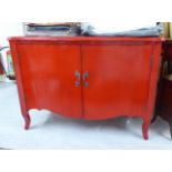A modern lacquered, serpentine front cupboard with a pair of full-height doors, raised on short,