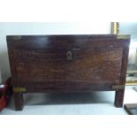 A 20thC Asian boarded teak trunk with brass corner reinforcement and flank bail handles,