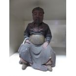 A modern 'antique' effect Chinese stained wooden figure, a seated bearded man,
