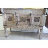 An Asian rustically constructed and profusely carved, bleached hardwood cupboard,