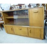 A mid 20thC light oak bookcase with two sliding glazed doors and four doors,