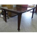 A 1920s stained oak finished extending dining table, the top with a thumb moulded edge,