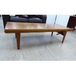 A 1970s teak coffee table, the top raised on square,