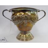 A silver bowl of pear design with a flared rim and opposing beaded loop handles, embossed flora,