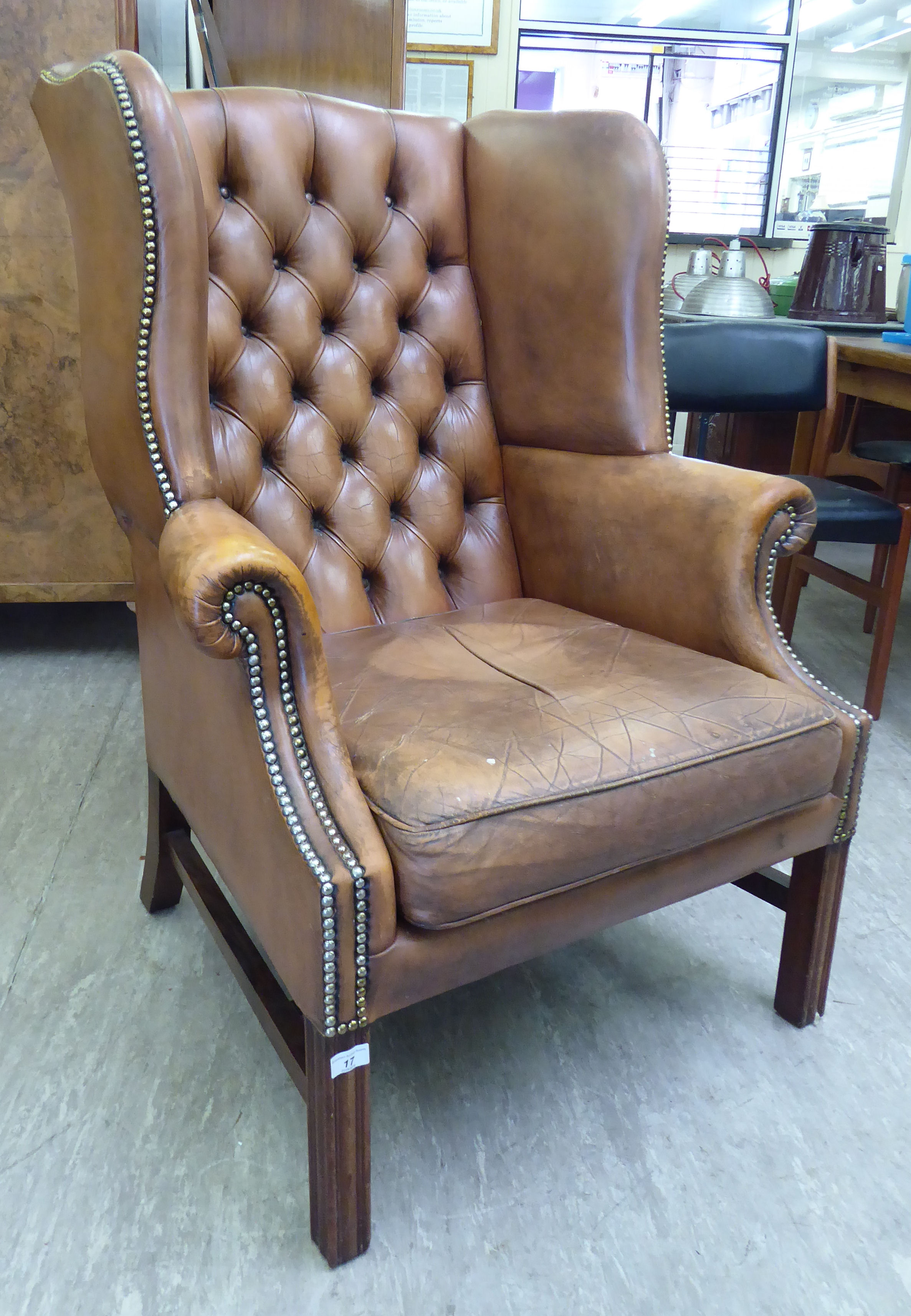 A modern Georgian design, buttoned brown hide upholstered wingback library chair,