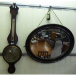 An Edwardian mahogany finished barometer 30''h; and a 1920s oval mirror,