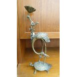 An early 20thC Chinese cast brass candlestick, fashioned as a tall flower beside a heron,