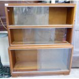 A mid 20thC teak 'Minty' three section stacking bookcase with glazed sliding doors,