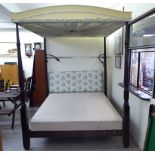 A modern mahogany finished four poster bed with a fabric canopy and an upholstered headboard 92''h