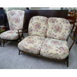 An Ercol stained beech and elm framed two seater settee; and a matching open arm chair,