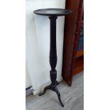 An Edwardian mahogany torchere with a demi-reeded, husk carved column,
