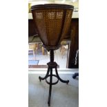 A late Victorian mahogany jardinere stand with a wicker basket, raised on splayed,