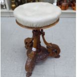A late Victorian walnut framed revolving, height adjustable piano stool,