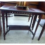 An Edwardian mahogany occasional table with a fretworked frieze, raised on turned,