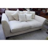 A modern three person settee, upholstered in cream coloured fabric,