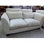 A modern two person settee, upholstered in cream coloured fabric,