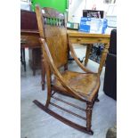 An early 20thC American style stained beech framed rocking chair, the pierced,