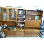 A 1970/80s teak three-section wall unit, comprising two glazed doors, a fall flap,