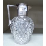 An Edwardian hobnail cut glass claret jug with a silver collar, spout,