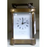 A Matthew Norman brass cased carriage timepiece with a swing top handle, faced by a Roman dial,