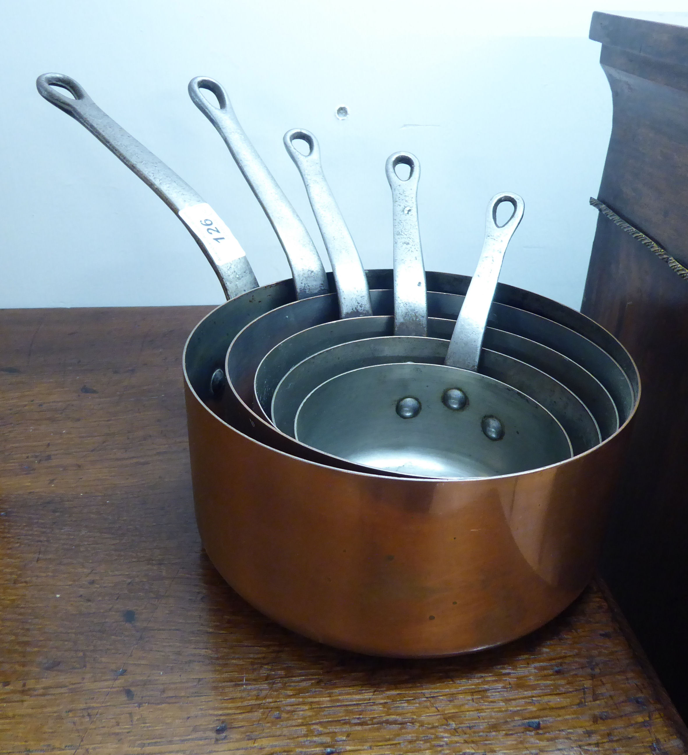 A graduated set of five Victorian style copper saucepans with iron handles BSR