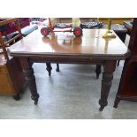 A 1920s mahogany finished dining table, the top with canted corners, raised on ring turned,