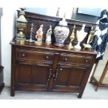 An Ercol dark oak court cupboard with an arrangement of four doors and two drawers,