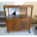 A modern yew finished serving trolley with a removable tray top, over two doors,
