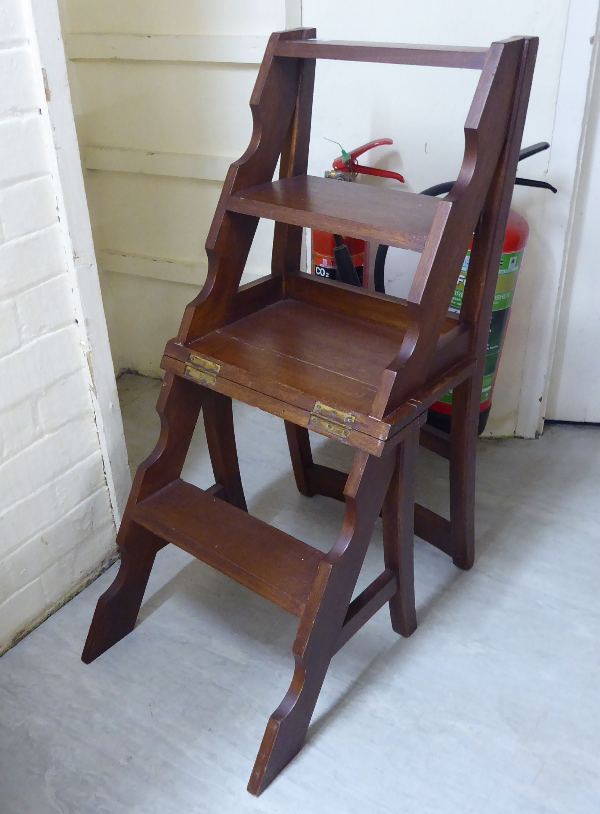 A mid 20thC mahogany metamorphic library chair with four tread steps,