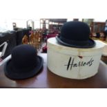 Two similar black bowler hats various sizes;