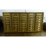 An Emir of Ashford teak and pine finished table-top filing cabinet with forty drawers,
