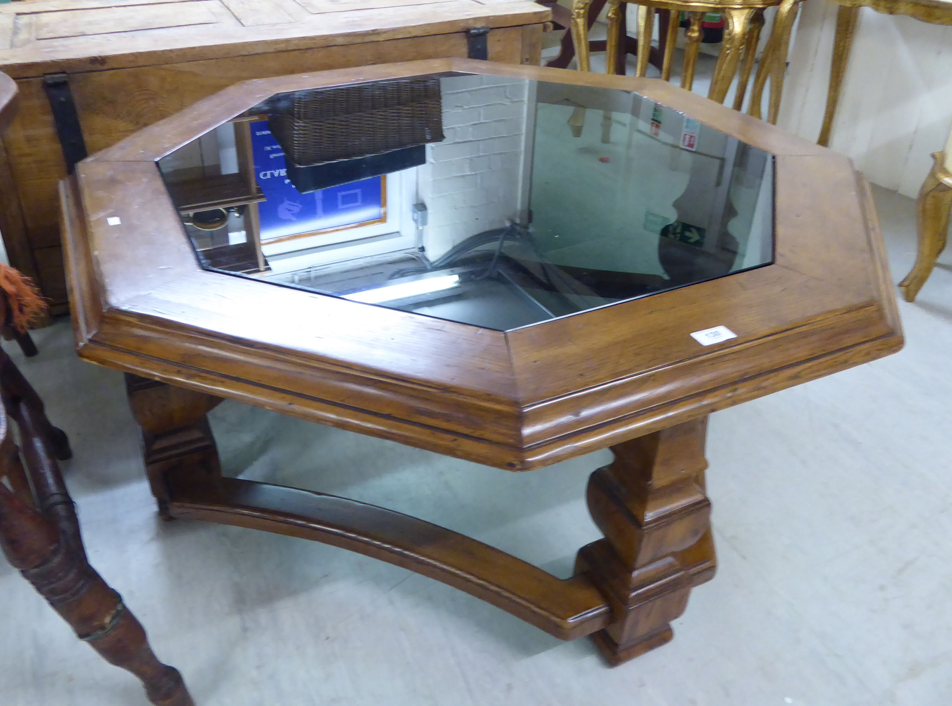 A modern coffee table of octagonal form, the inset, tinted glass top set in an oak frame,