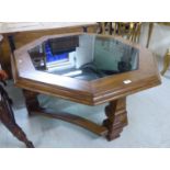 A modern coffee table of octagonal form, the inset, tinted glass top set in an oak frame,