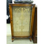 A 1950s walnut finished serpentine front display cabinet with a glazed door,