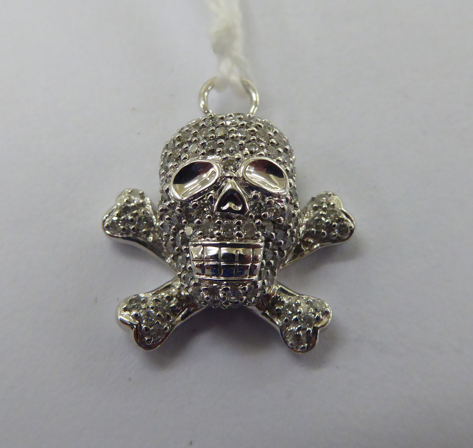 An 18ct white gold skull and crossbones pendant,