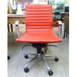 A modern desk chair, the chromium plated frame with a stitched red hide cushioned back and seat,