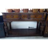 A modern reproduction of a Jacobean, stained oak dresser with three frieze drawers,