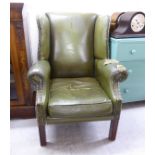 A mid 20thC Georgian style wingback armchair, stud upholstered in green hide,
