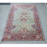 An Indian woollen rug decorated with stylised designs on a multi-coloured ground 74'' x 72''