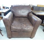 A modern armchair, upholstered in brown hide,