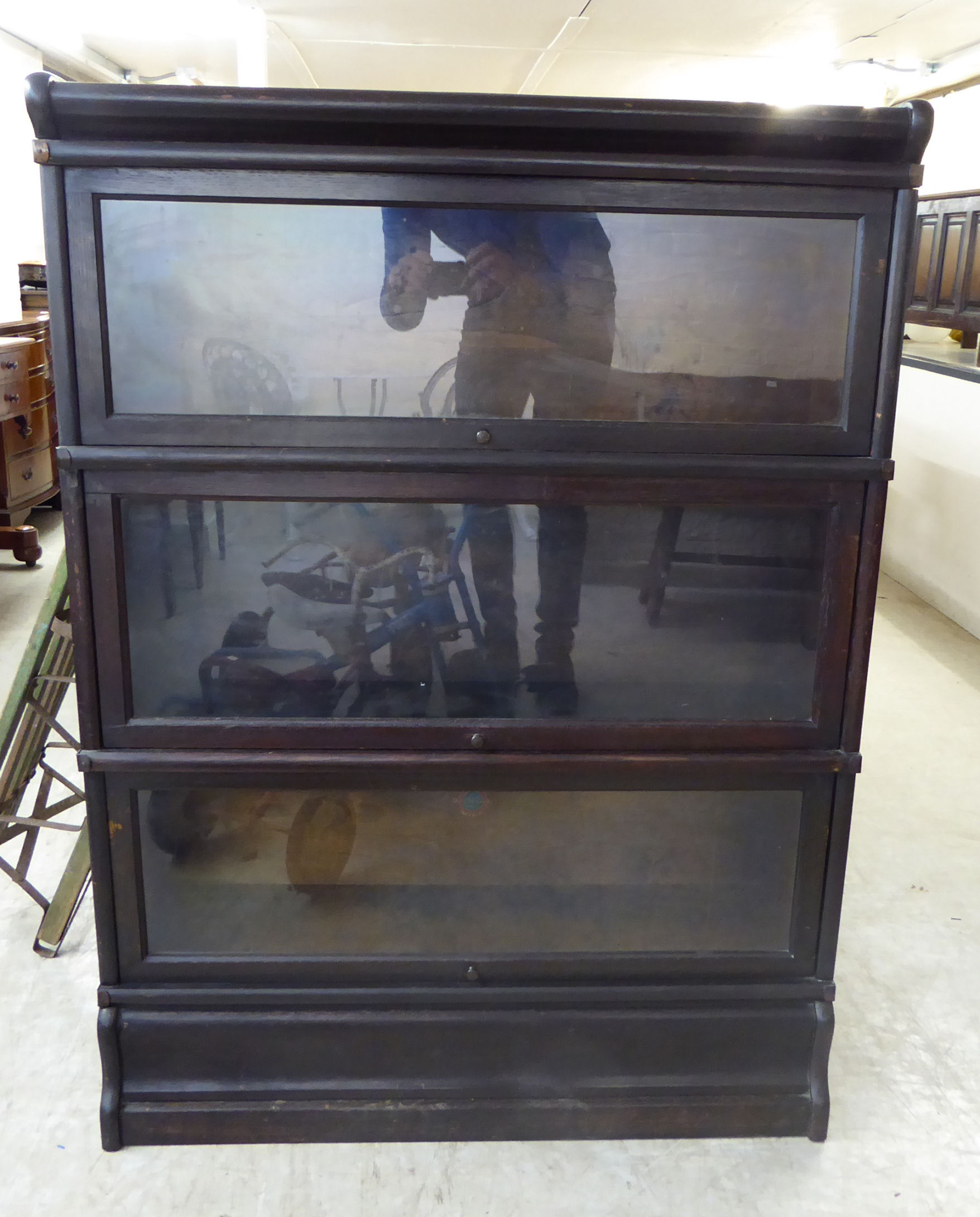 An early 20thC Globe Wernicke painted oak bookcase with three glazed sections,
