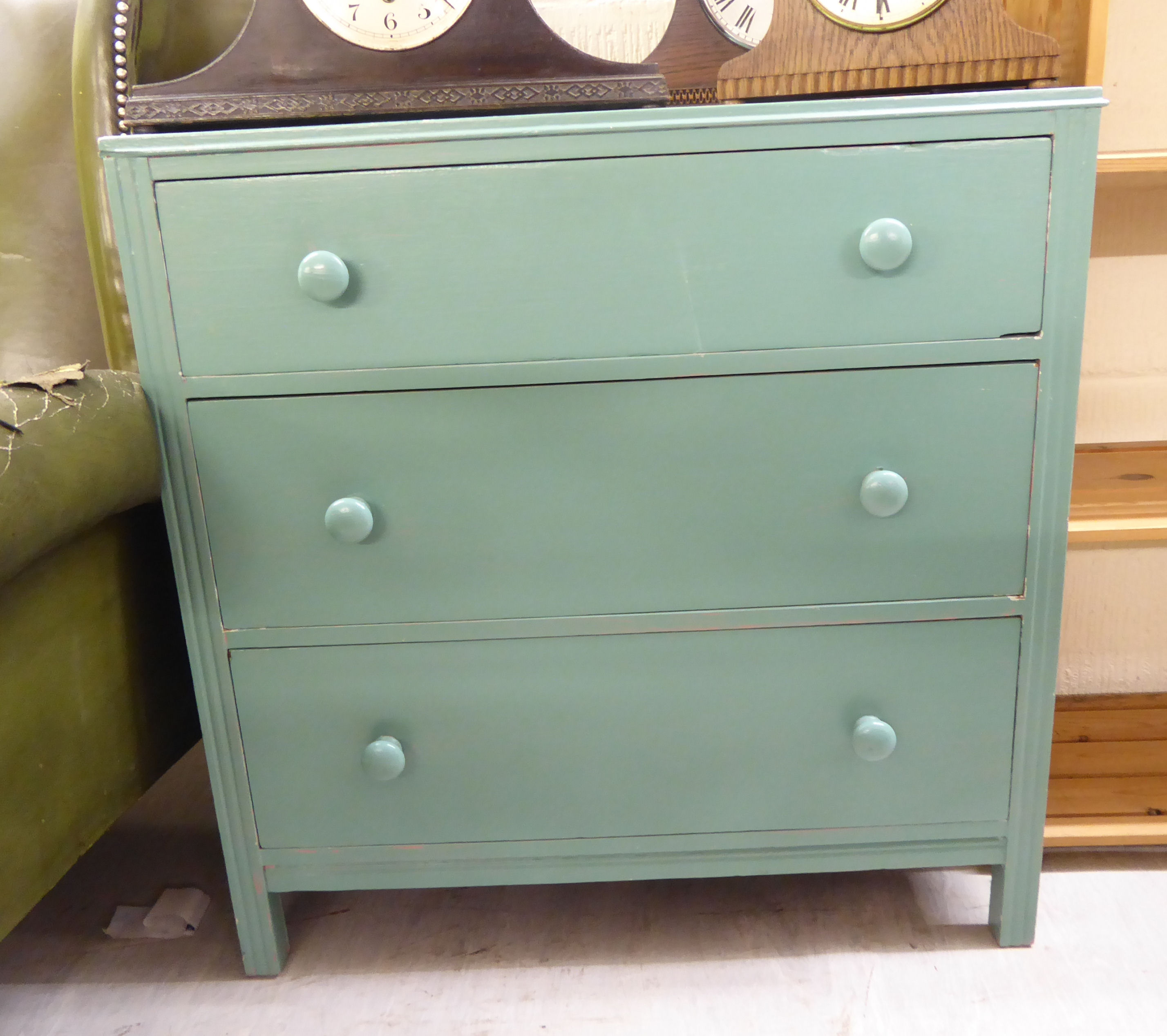 An early/mid 20thC green painted pine, three drawer dressing chest,