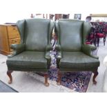 A pair of mid 20thC Georgian style wingback studded green hide upholstered,