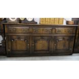 A modern reproduction of an Old English style, stained oak dresser with three in-line drawers,