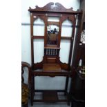 An early 20thC mahogany framed hallstand, the broken arch pediment over a central bevelled,