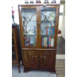 An Art Deco crossbanded walnut finished display cabinet with a pair of glazed doors,